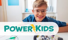 PowerKids logo. Background: smiling child in library